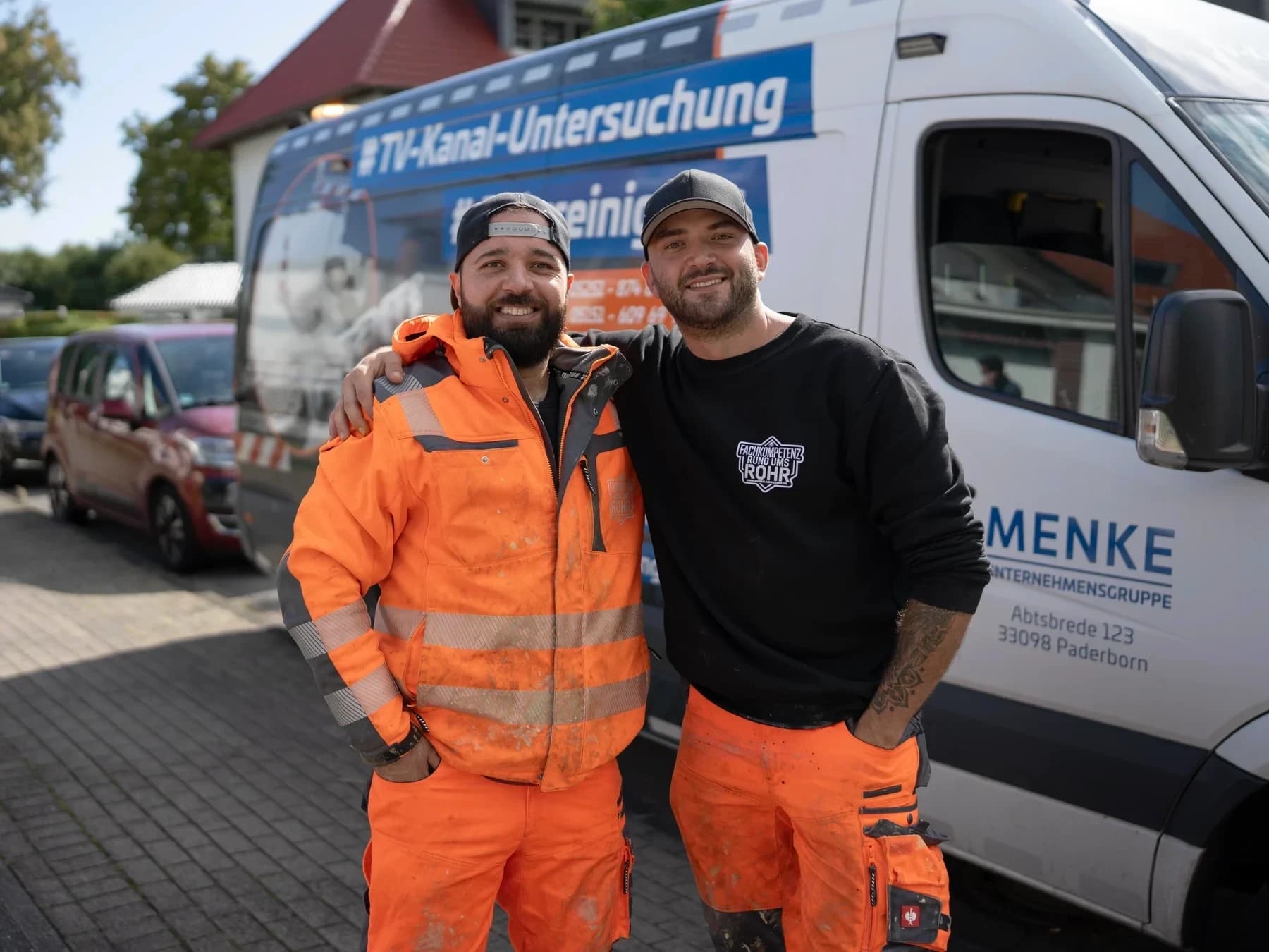 Zwei Monteure von Menke Umweltdienste vor dem Einsatzfahrzeug für Rohrreinigung und TV-Kanaluntersuchung in Paderborn