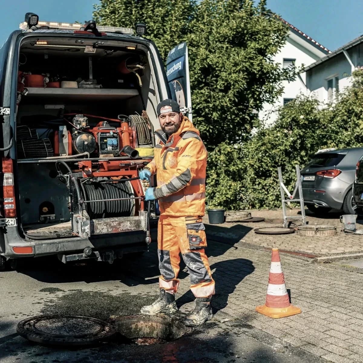 Monteur von Menke Umweltdienste führt die Reinigungsspirale in den offenen Schacht